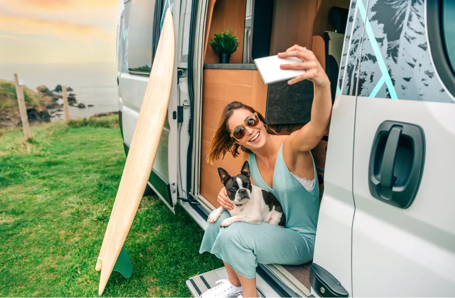 Locataire prenant un selfie avec son chien devant le van
